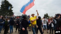 Демонстранта з прапором Росії затримує ОМОН під час антикорупційного протесту в Санкт-Петербурзі, 12 червня 2017 року