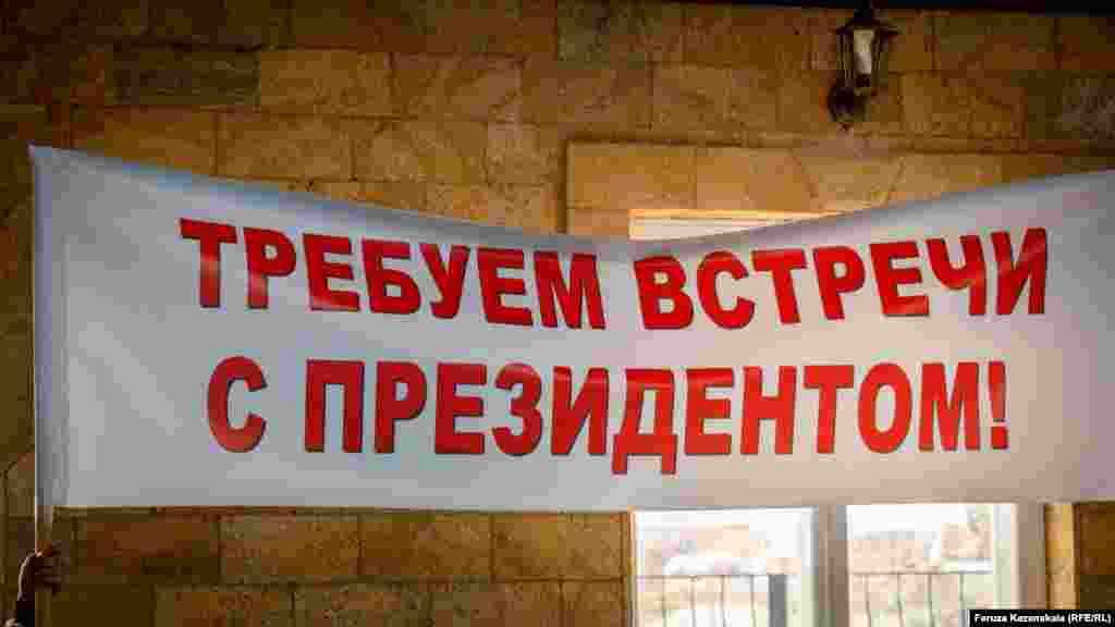 Вони тримали плакати із гаслами: &laquo;Президенте! Захисти від знесення наші будинки й мечеть&raquo;, &laquo;Президенте! Зупини свавілля кримської влади&raquo;, &laquo;Вимагаємо зустрічі з президентом&raquo;