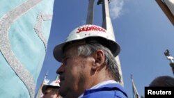 Poland - Solidarity activists hold flags as they attend a gathering celebrating the 30th anniversary of the Solidarity Movement, or "Solidarnosc", at the shipyard workers monument in front of the Gdansk Shipyard, 31Aug2010