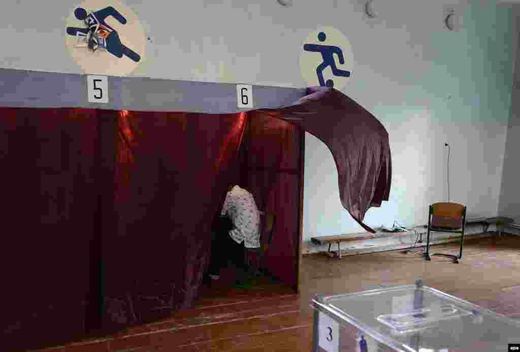 A voter prepares his ballot in a voting booth set up in a gym of the Novospasskoye village in Dnipropetrovsk, some 400 kilometers southeast of Kyiv, Ukraine, on May 25. (epa/Filip Singer)