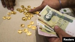 A customer buys Iranian gold coins at a currency exchange office in Tehran's business district.