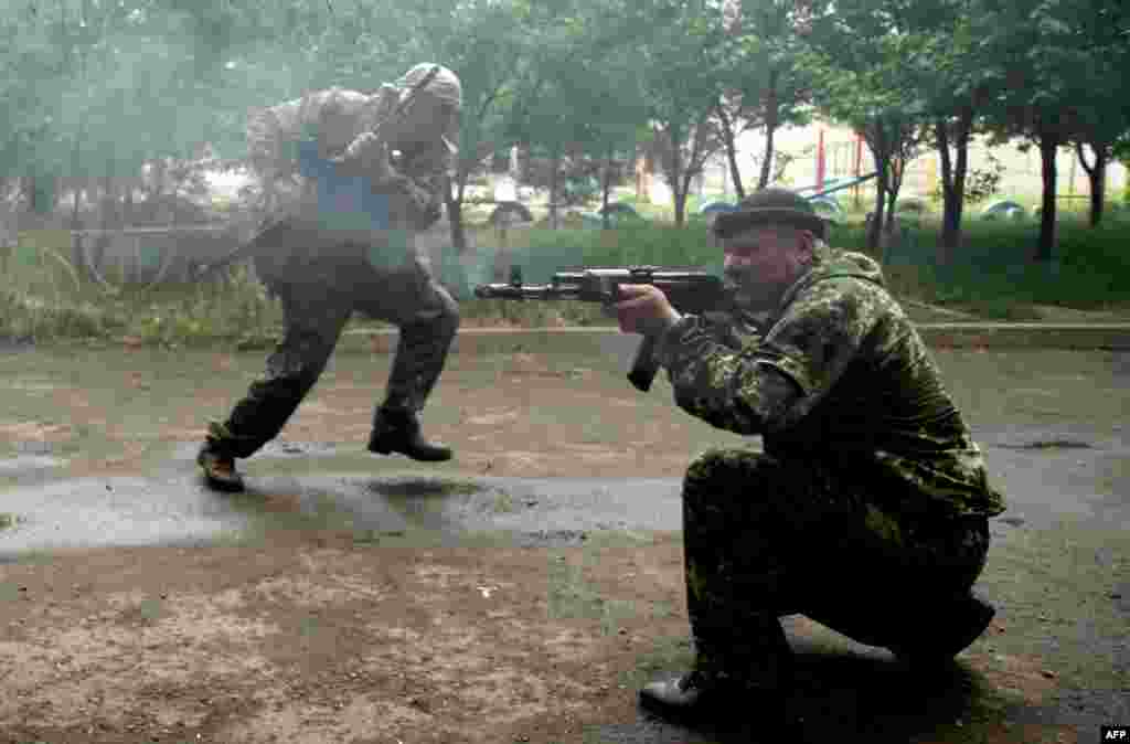 Pro-Russia militants fire at Ukrainian border guards defending the Federal Border Headquarters in Luhansk on June 2. (AFP/Sergei Gapon)