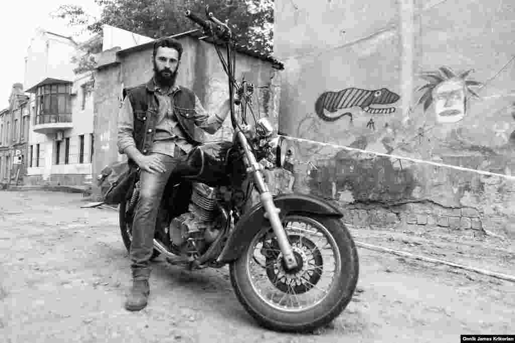 Nikoloz Koberidze, 24, on his motorbike outside the Cross Riders MC clubhouse and bar on a side street past the Tbilisi Opera House.