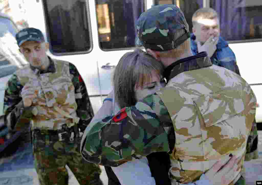 A young Ukrainian volunteer and member of the Maidan self defense forces is embraced by his girlfriend on Kyiv&#39;s Independence Square before his deployment at a training facility. 