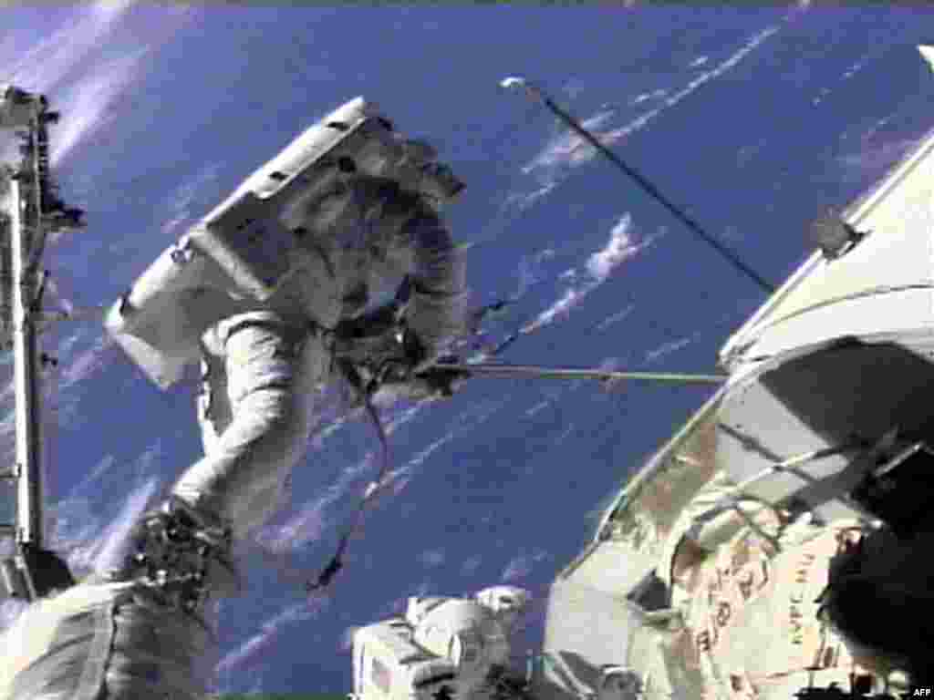 U.S. space shuttle "Endeavour" crew member Jim Newman (left) works at freeing a sticking antenna on the "Zarya" module of the International Space Station as crew member Jerry Ross (center) looks on. This was one of the ISS's first early hiccups, but was resolved successfully.