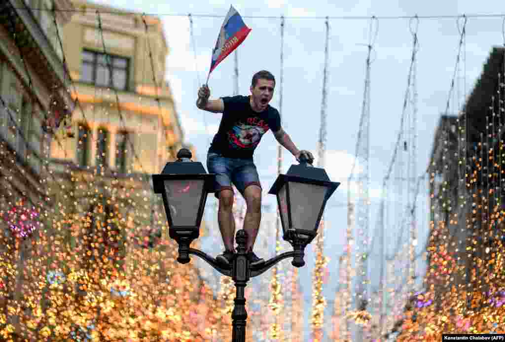 A Russian fan celebrates in central Moscow after Russia won its knockout match in the Round of 16 against Spain on July 1 in the 2018 World Cup. (AFP/Konstantin Chalabov)