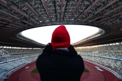Журналіст робить фото на Національному стадіоні в Токіо, який мав стати головною ареною Олімпіади-2020. 15 березня 2020 року