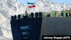 An Iranian flag flies on the oil tanker Adrian Darya 1, previously named Grace 1, as it sits anchored after authorities in the British territory lifted their detention order in mid-August.