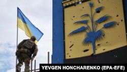 უკრაინელი სამხედრო აღმართავს უკრაინის დროშას გათავისუფლებული ხარკოვის ოლქის და დონეცკის ოლქის ადმინისტრაციულ საზღვართან. 2022 წლის 20 სექტემბერი