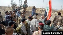 Премьер-министр Ирака поднимает флаг над освобожденной от «ИГ» территорией.