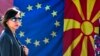 Një grua duke kaluar pranë flamurit të BE-së dhe atij të Maqedonisë së Veriut, Shkup, shkurt 2020