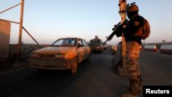 An Iraqi soldier stands guard at a check point in west Baghdad. (file photo)