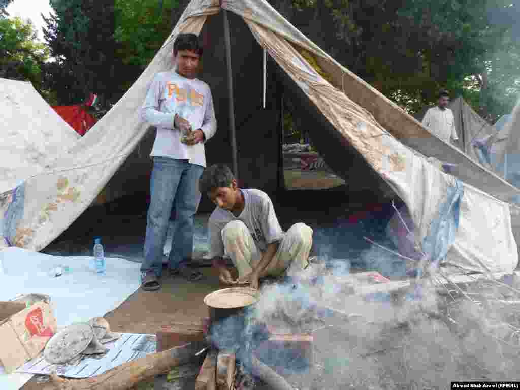 Young men prepare tea with milk at the protest camp near the parliament in Islamabad. 