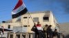 Иракский военный держит флаг в центре Рамади