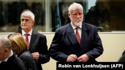 Former Bosnian Croat Defense Minister Bruno Stojic (left) and former General Slobodan Praljak wait in court prior to the judgement in their appeals case on November 29.