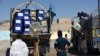 Employees of the Afghan Independent Election Commission (IEC) unload ballot boxes from a turck at a polling centre ahead of legislative election in Kandahar Province on October 26.