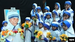 Девочки, одетые как Мать Тереза, у ее портрета в 2014 году – в 104-ю годовщину со дня рождения монахини 