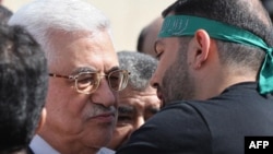 Palestinian President Mahmud Abbas (left) welcomes a prisoner wearing a Hamas headband following the release of hundreds of prisoners from Israeli jails in October.