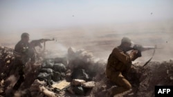 Бойцы курдского отряда "пешмерга" в бою против представителей группировки "Исламское государство". Окрестности Мосула, 9 сентября 2014 года.