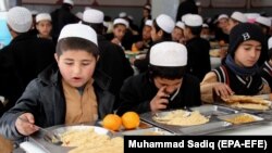 Afghan orphans, who lost their parents in fighting, eat a meal at Sheikh Mohammed Bin Rashid al-Maktoum orphanage house in the southern city of Kandahar on February 20.