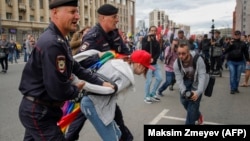 Police detain an LGBT activist during a protest in Moscow on August 26.