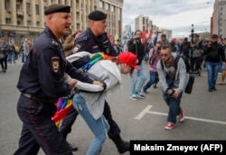 Police detain an LGBT activist during a protest in Moscow.