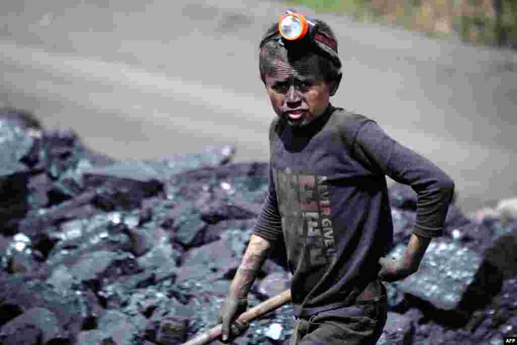 An Afghan child looks on as he works at a coal mine which collapsed on April 30, killing some 40 miners and trapping an unknown number of others in the Dar-i-Suf district of Samangan Province. (AFP/Farshad Usyan)