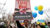 Egy tüntető plakátot tart a magasba egy háborúellenes tüntetésen a kazahsztáni Almatiban