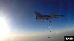 A still image taken from video footage and released by Russia's Defense Ministry on August 14 shows a Tu-22M3 dropping bombs near what the ministry said is the city of Deir ez-Zor, Syria.