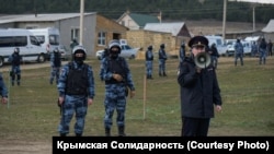 Российские силовики стоят в оцеплении в поселке компактного проживания крымских татар. Крым, 27 марта 2019 года
