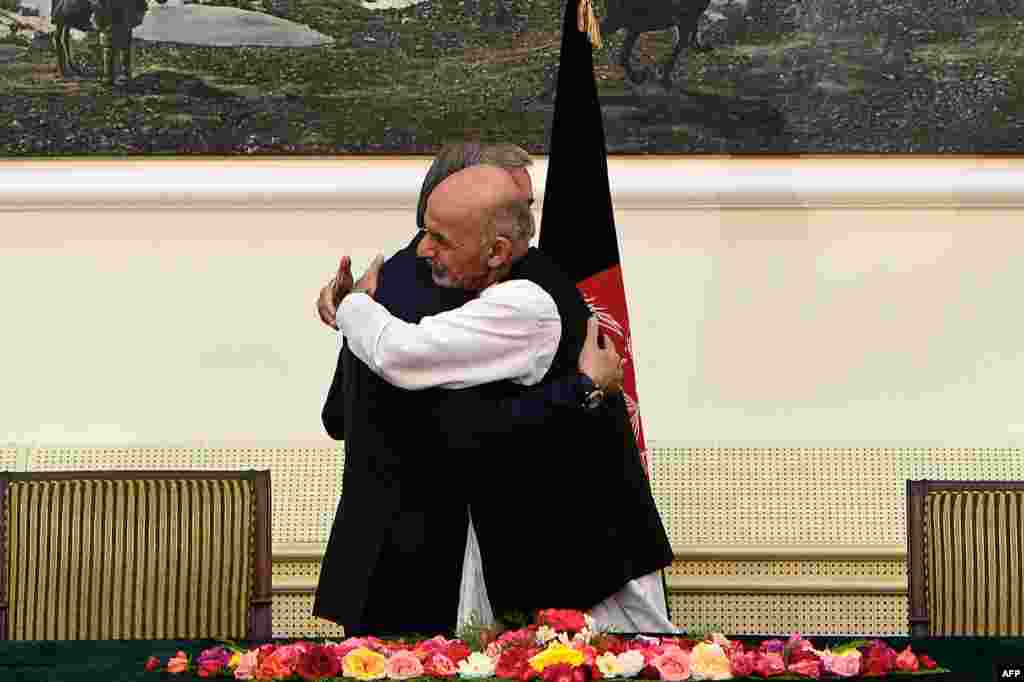 Afghan presidential candidates Abdullah Abdullah (left) and Ashraf Ghani&nbsp;embrace after signing a power-sharing agreement at the Presidential Palace in Kabul, ending a prolonged standoff over disputed election results at a pivotal moment in the war-weary nation&#39;s history. (AFP/Wakil Kohsar) 