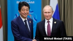 Russian President Vladimir Putin (right) and Japanese Prime Minister Shinzo Abe meet at a summit in Vietnam last year. 