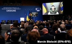 Președintele ucrainean Volodimir Zelenski se adresează delegaților prin intermediul unei legături video în timpul unei conferințe internaționale privind reconstrucția și redresarea Ucrainei, care a avut loc la Berlin în octombrie.