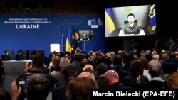 Украинанын президенти Владимир Зеленский видео аркылуу өлкөнү калыбына келтирүү боюнча эл аралык конференциянын катышуучуларынын алдында сүйлөп жатат. Берлин, 25-октябрь, 2022-жыл.