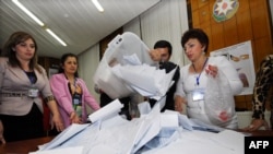 Azerbaijani election officials empty ballot boxes at a polling station in Baku on October 9.