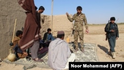 Afghan Local Police officers stand at a checkpoint in Helmand.