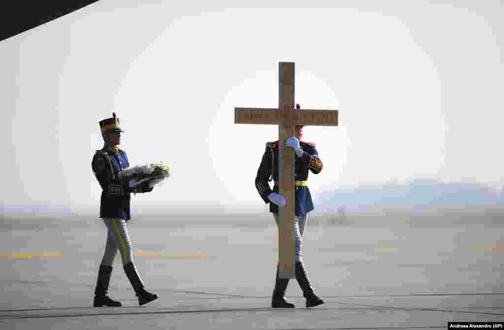 Honor guard soldiers carry a cross during the repatriation of the remains of Helen of Greece and Denmark, Romania&#39;s Queen Mother who is noted for her efforts to save Romanian Jews during World War II, at an airport outside Bucharest. (AP/Andreea Alexandru)