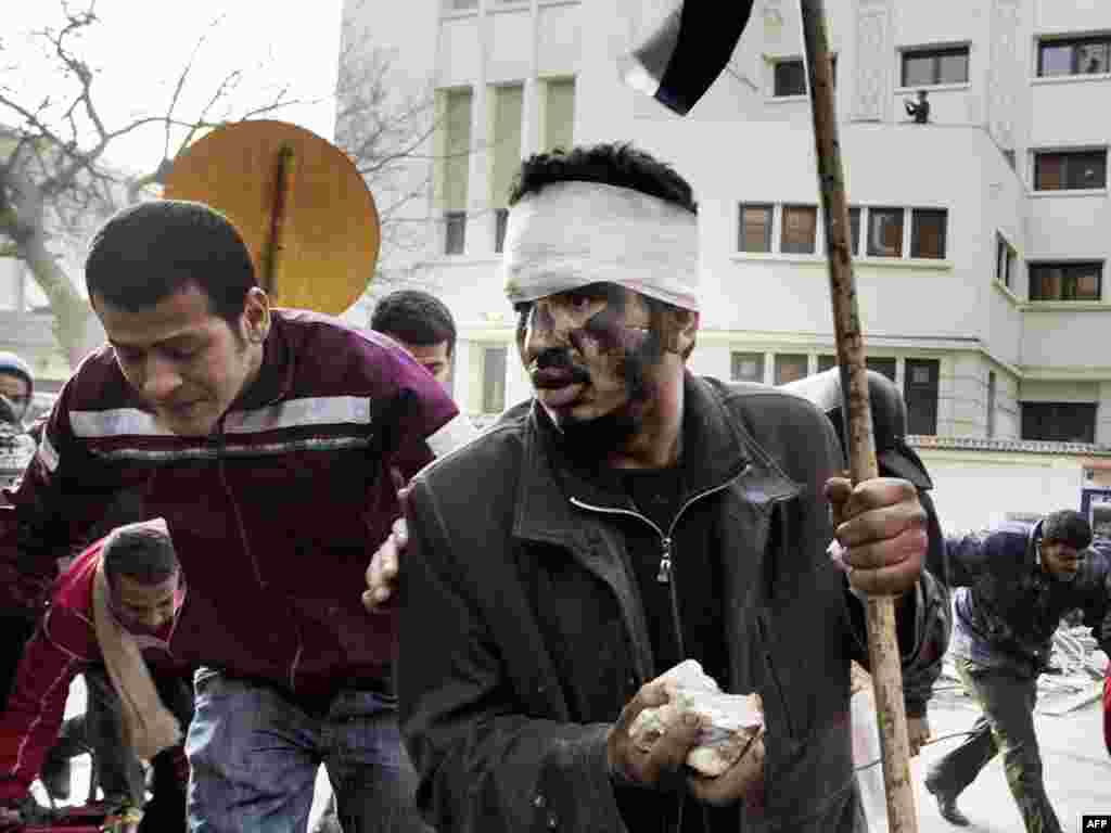 Демонстрациячеләр Каһирәнең үзәк мәйданын янында халык төркеменә ут ачкан полициядән кача. 29 гыйнвар 2011.