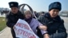 Kyrgyz police arrest a woman protesting against gender-based violence to mark International Women's Day in Bishkek in March 2020.