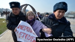 Kyrgyz police arrest a woman protesting against gender-based violence to mark International Women's Day in Bishkek in March 2020.