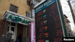 Табло с курсами покупки и продажи иностранной валюты рядом с обменником в Алматы. 11 февраля 2014 года.