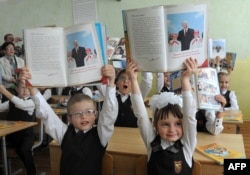 Первоклассники показывают книгу об Александре Лукашенко на одном из первых уроков в школе