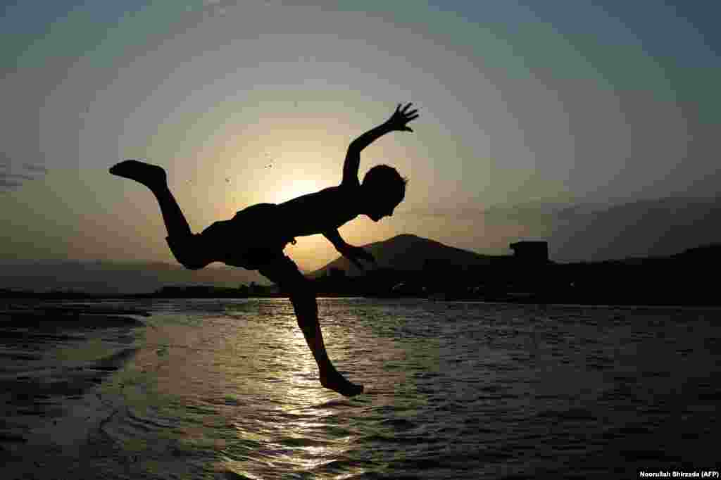 An Afghan youth jumps into a river on the outskirts of Jalalabad. (AFP/Noorullah Shirzada)