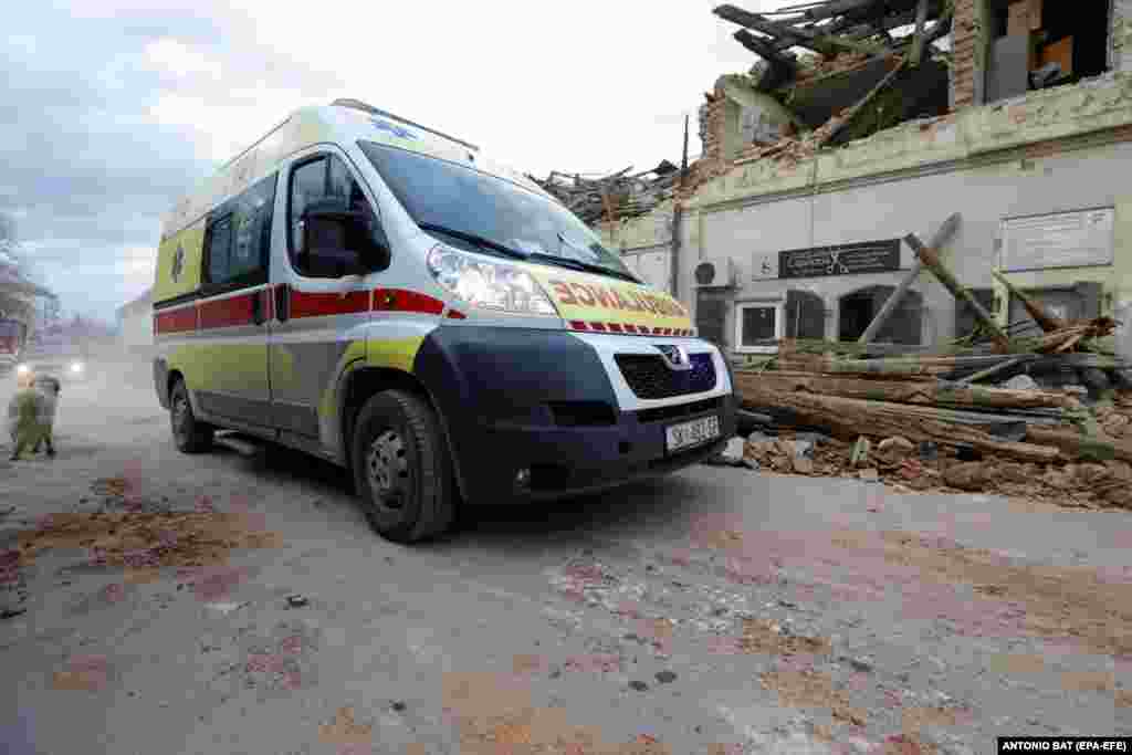 An ambulance car drives past buildings damaged in an earthquake in Petrinja, Croatia, 29 December 2020.&nbsp;EPA-EFE/ANTONIO BAT