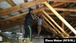 Рабочие ремонтируют чердачную крышу в доме, пострадавшем в результате взрыва отопительного котла. Поселок Шахан Карагандинской области. 23 июня 2017 года. 