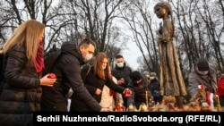 Біля Музею Голодомору встановили скульптуру дівчинки з колосками. До її ніг складають колоски, хліб, яблука, калину в День вшанування пам’яті жертв Голодомору-геноциду. Київ, 28 листопада 2020 року