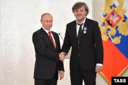 Президент России Владимир Путин (слева) и сербский режиссер Эмир Кустурица (справа), награжденный орденом Дружбы, 4 ноября 2016 года