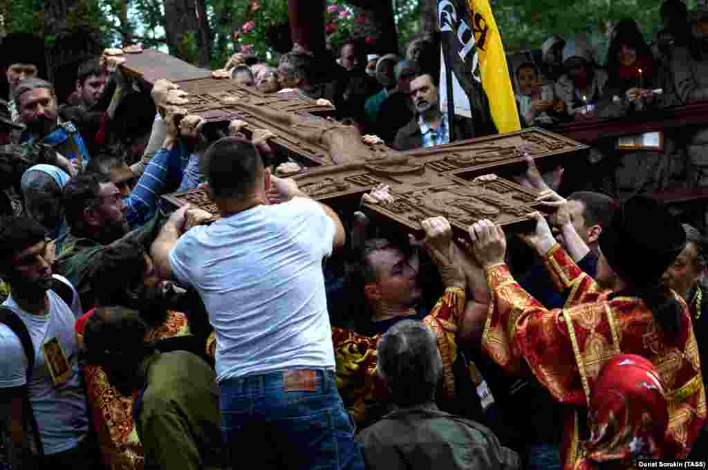 Marchers with a carved cross at the site where investigators discovered the bodies of Russia's last royal family. 
