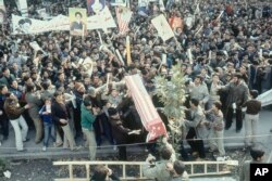 IRAN -- file -- Iranian Muslim men and boys carrying banners and posters of Ayatollah Khomeini protest outside the U.S. Embassy in Teheran, Iran, Nov. 1979.