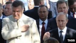 Украина президенті Виктор Янукович (сол жақта) пен Ресей президенті Владимир Путин шіркеудегі діни шара кезінде. Херсон, 28 шілде 2013 жыл.